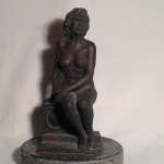 All'orizzonte, donna nuda seduta su un cubo. Scultura in bronzo di Gigi Busato, collezione di famiglia