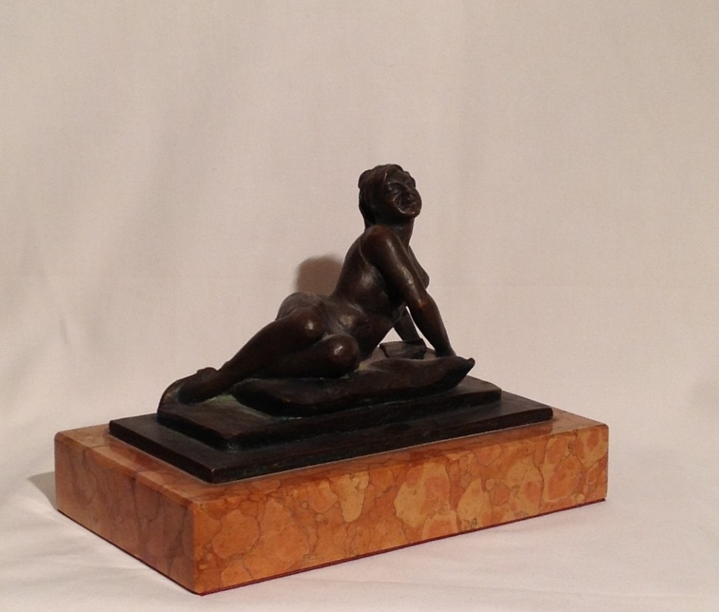 Sul cuscino di Gigi Busato, scultura in bronzo di una donna distesa in posa su un soffice cuscino. Collezione di famiglia