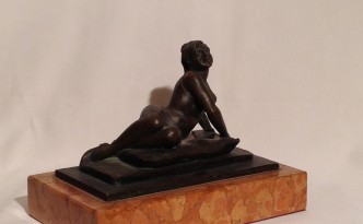 Sul cuscino di Gigi Busato, scultura in bronzo di una donna distesa in posa su un soffice cuscino. Collezione di famiglia