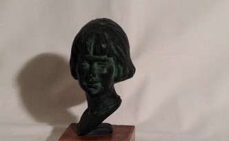 Voltino di Gigi Busato. Scultura in bronzo di un volto di una donna. Collezione di famiglia